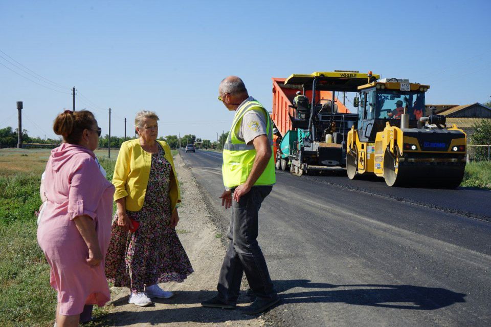 На последнем ненормативном участке автоподъезда в Питерском районе укладывают асфальтобетона