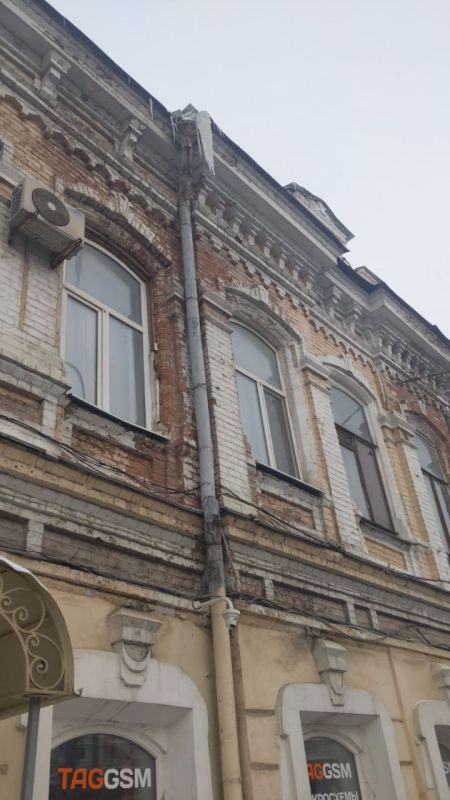 В центре города с крыш продолжают угрожающе свисать гигантские сосульки